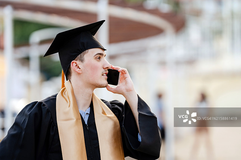 高中毕业生在毕业典礼后打电话图片素材