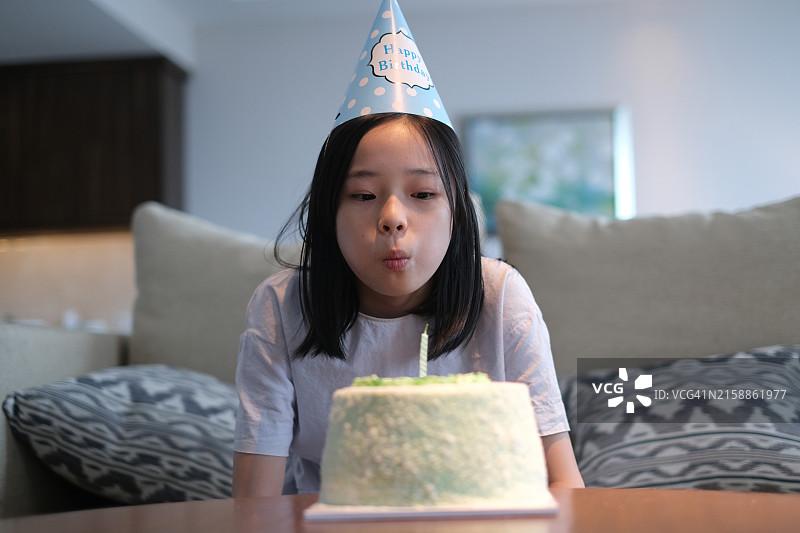 中国少女在家吹生日蛋糕图片素材