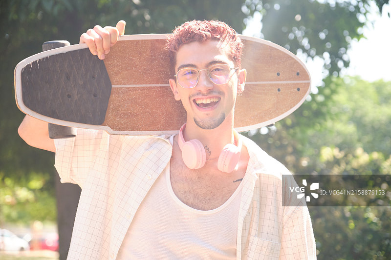 手拿滑板微笑的男人图片素材