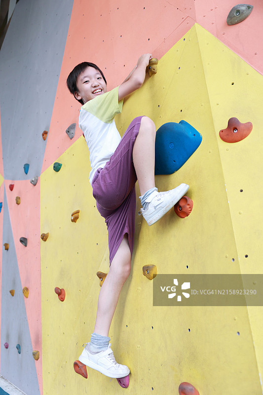 攀爬室内攀岩墙的男孩图片素材