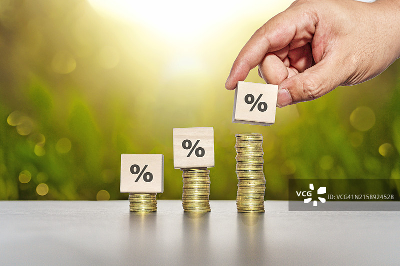 手持木块上的百分比符号，堆叠以表示利率和商业利润增长概念图片素材