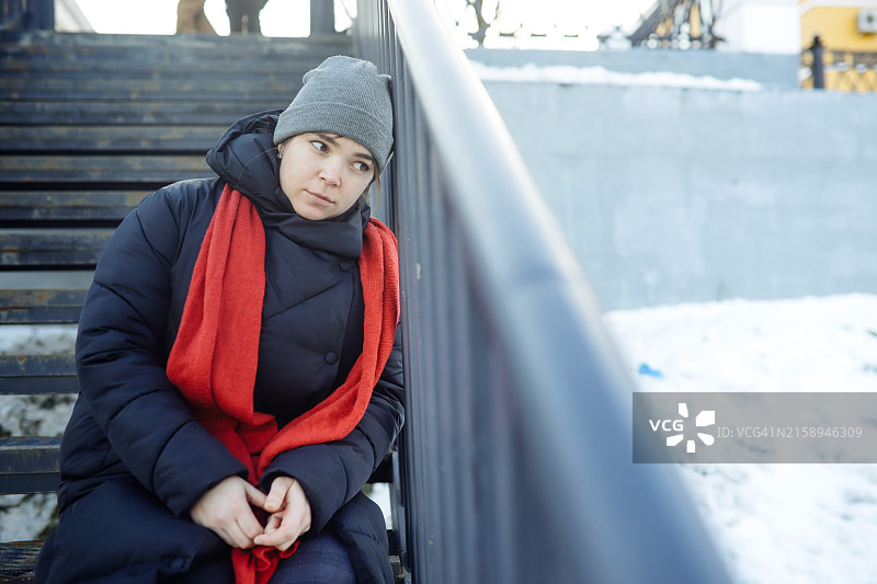孤独：陷入抑郁的中年妇女在城市街道楼梯上寻求慰藉图片素材