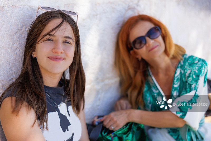 快乐的少女与母亲在户外度过时光，游览古镇图片素材