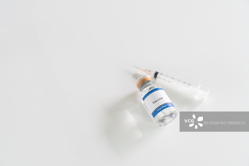 桌子上的疫苗和注射器：疫苗接种概念图片素材
