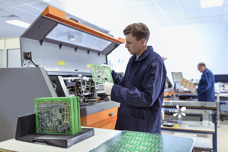 电路板厂工人操作飞针测试机图片素材
