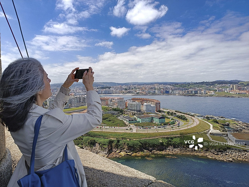 游客在拉科鲁尼亚用手机拍摄海格力斯塔图片素材