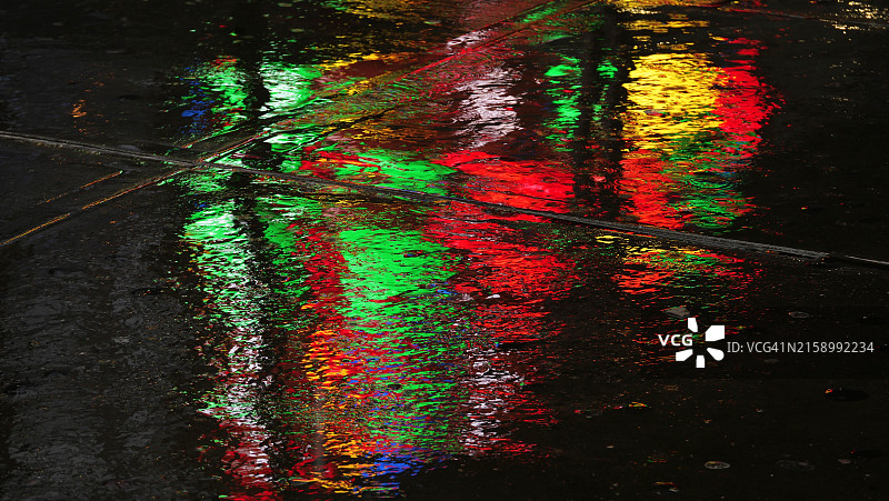 时代广场广告屏幕在人行道水坑中的明亮倒影图片素材