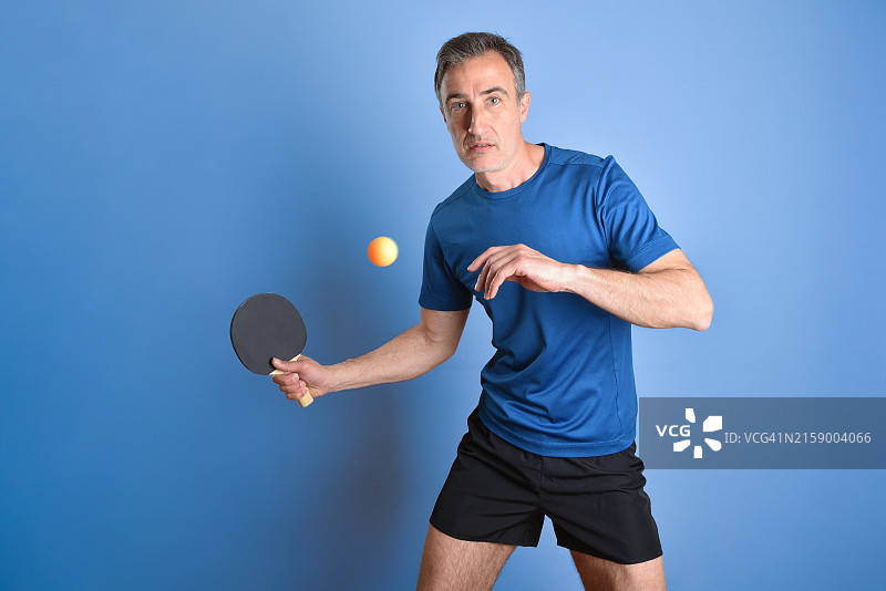 男人手持球拍，背景为蓝色图片素材