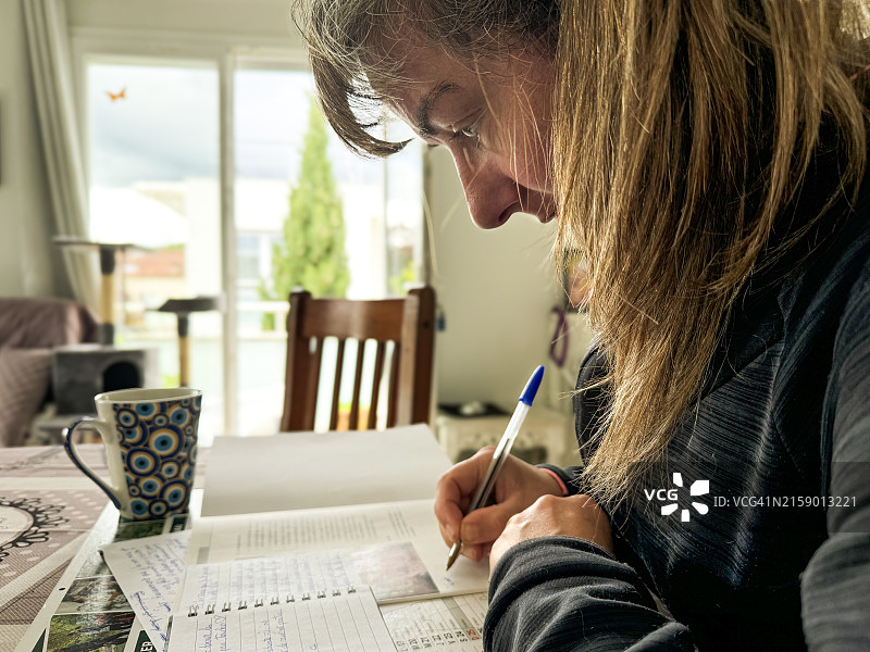 女子在桌旁看书写作图片素材