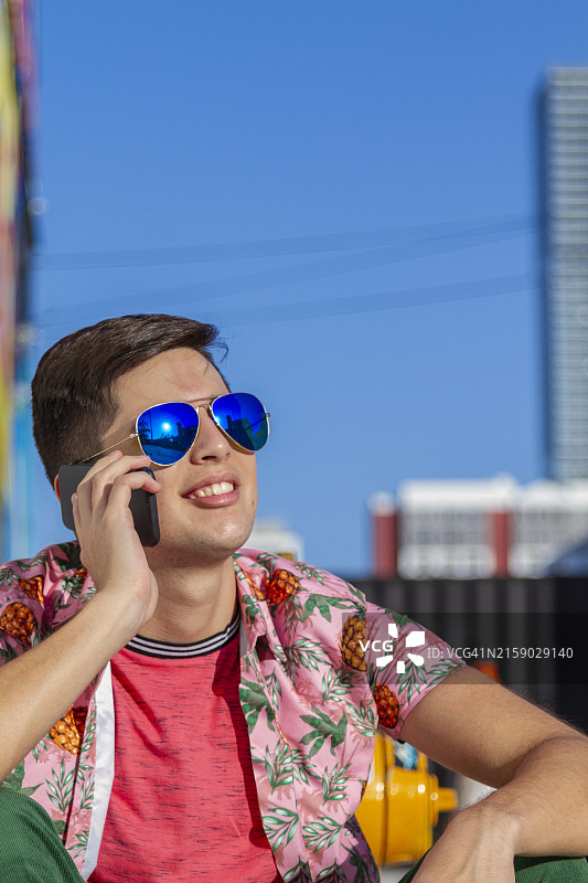 在迈阿密海滩滑板的拉丁裔男大学生使用5G技术图片素材