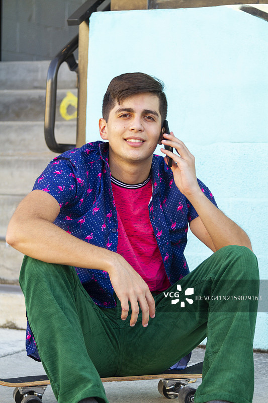 在迈阿密海滩滑板的拉丁裔男大学生使用5G技术图片素材