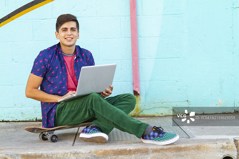 拉丁裔男大学生在Wynwood区和迈阿密设计区使用笔记本电脑图片素材
