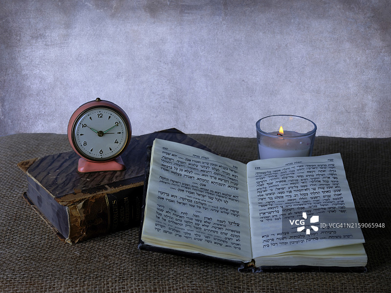 复古时钟、闪烁的蜡烛和打开的书本带来的永恒宁静图片素材