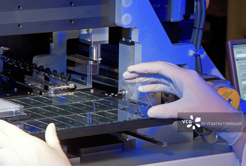 高科技制造环境中小心操作精密元件的技术员图片素材