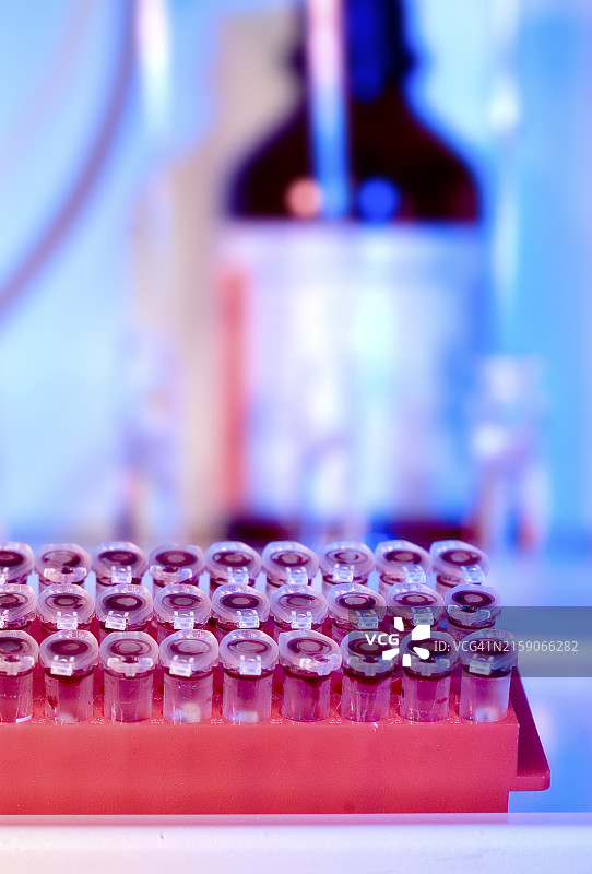 实验室环境中试管架上的彩色模糊光晕图片素材