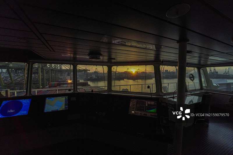 透过船桥的窗户看到的日出，可见导航设备图片素材