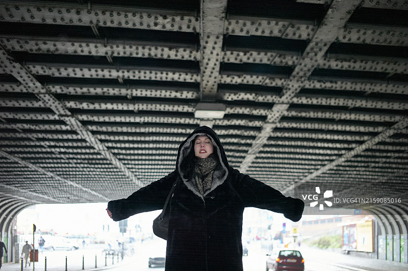 在城市桥下张开双臂的人图片素材