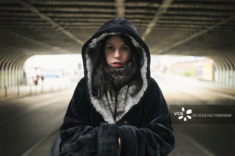 站在桥下隧道前的戴帽衫女人图片素材