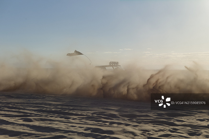 车辆在沙漠中疾驰，扬起漫天尘土图片素材