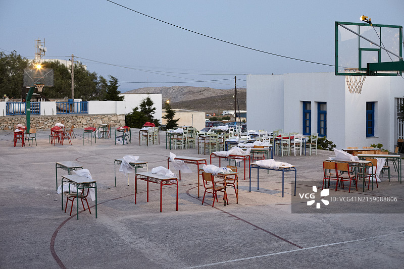 黄昏时分的户外场景：篮球场、桌椅和白色建筑图片素材