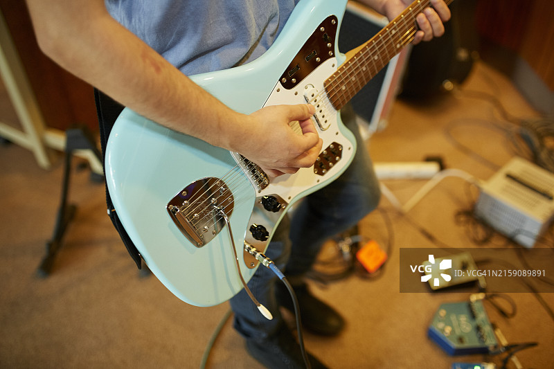 电吉他演奏特写：手部拨弦与琴身图片素材