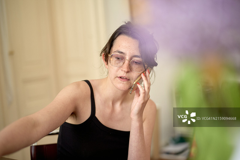 戴眼镜的人在室内拿着手机通话图片素材