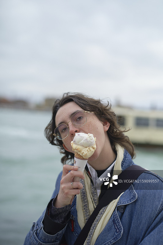 在水边享用冰淇淋的年轻人图片素材