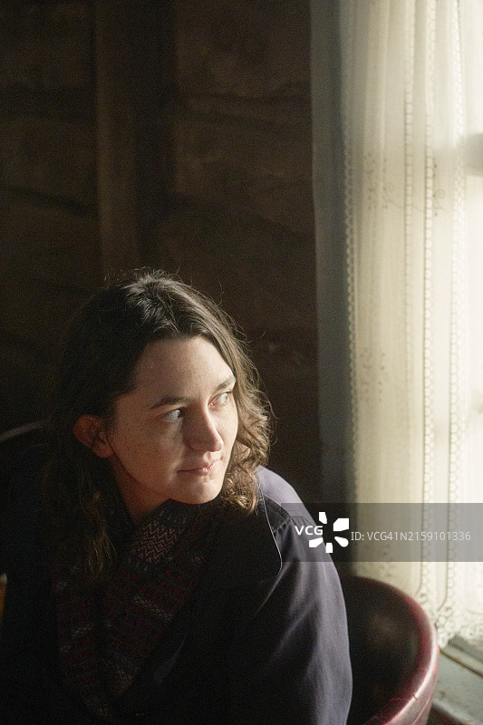 沐浴在自然光中，表情沉思的女人图片素材