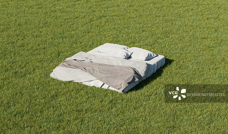 铺着白色床单的舒适床铺在草地上图片素材