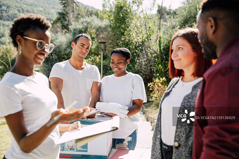 不同文化背景的年轻志愿者在街头分发宣传单图片素材