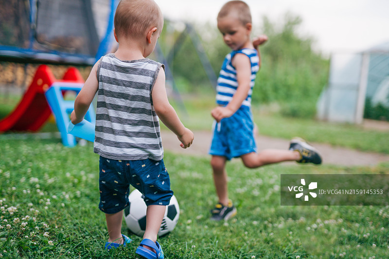 男孩们在后院踢足球图片素材