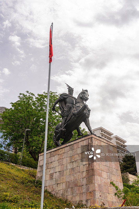 阿尔巴尼亚历史的英雄写照：斯坎德培雄伟的骑马雕像俯瞰着克鲁亚，伴随着国旗图片素材
