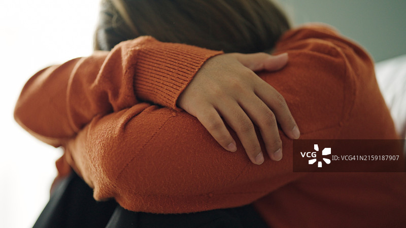 在卧室里拥抱自己的沮丧女人图片素材