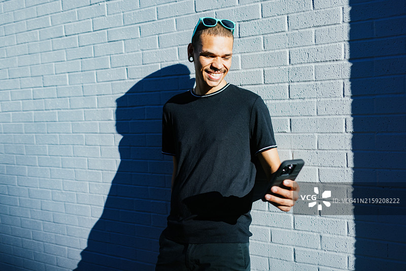 使用智能手机的快乐微笑的男人图片素材