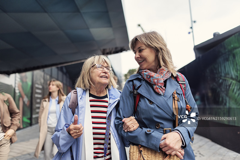 中年妇女和她的年长母亲在法国尼斯阿尔卑斯-滨海省火车站附近散步图片素材