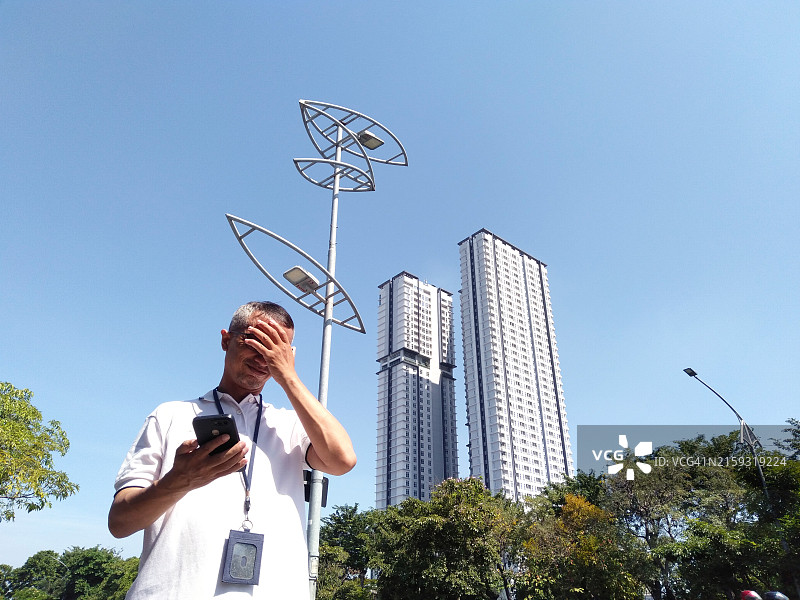 一个男人因遭遇网络诈骗而感到难过图片素材