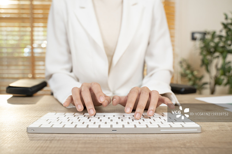 商务女人手，电脑鼠标和键盘在办公桌上打字，进行在线互联网搜索和数字营销，特写图片素材
