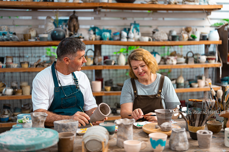 两个快乐的退休人员在做陶器图片素材