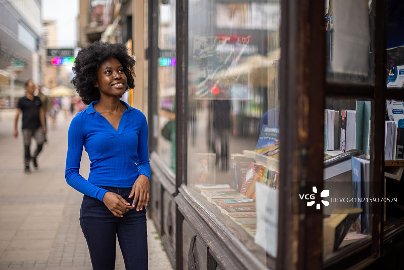 在书店橱窗前观看的女人图片素材