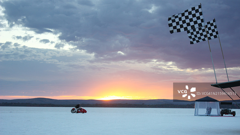 摩托车在干涸盐湖上被推向起跑线，艾尔半岛日出图片素材