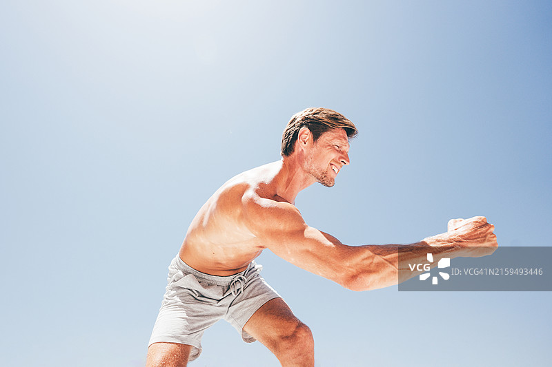 年轻男子展示他的肱二头肌。图片素材