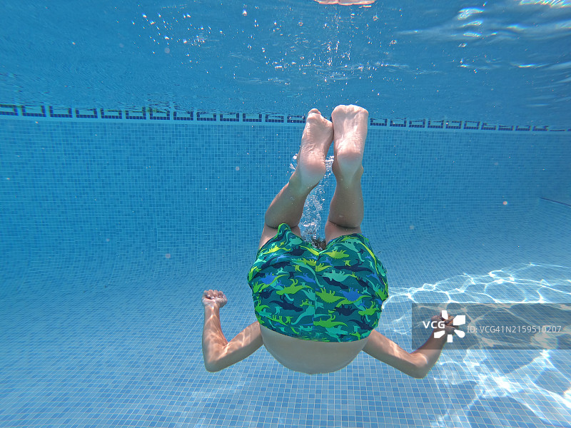 男孩在泳池潜水的水下镜头图片素材