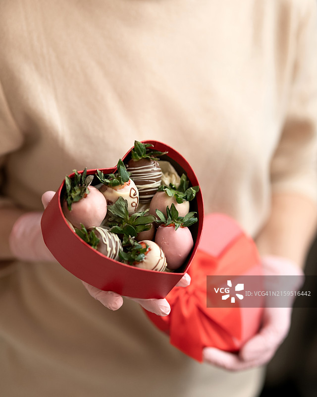 厨师手中的红色心形礼盒装巧克力草莓甜点图片素材