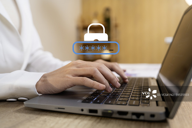 手在带有密码登录屏幕的笔记本电脑上打字，网络安全概念图片素材