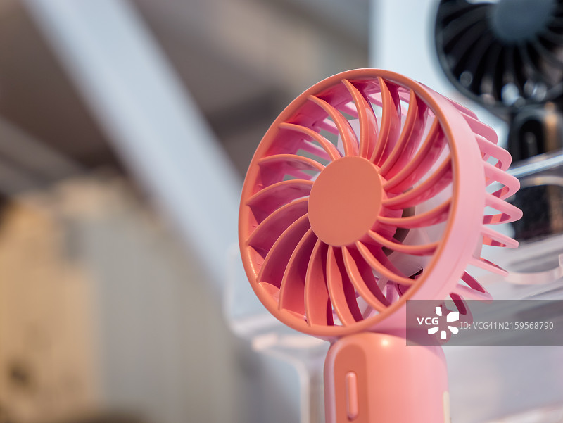 度过热浪：粉色手持便携式电池供电风扇用于保持凉爽图片素材