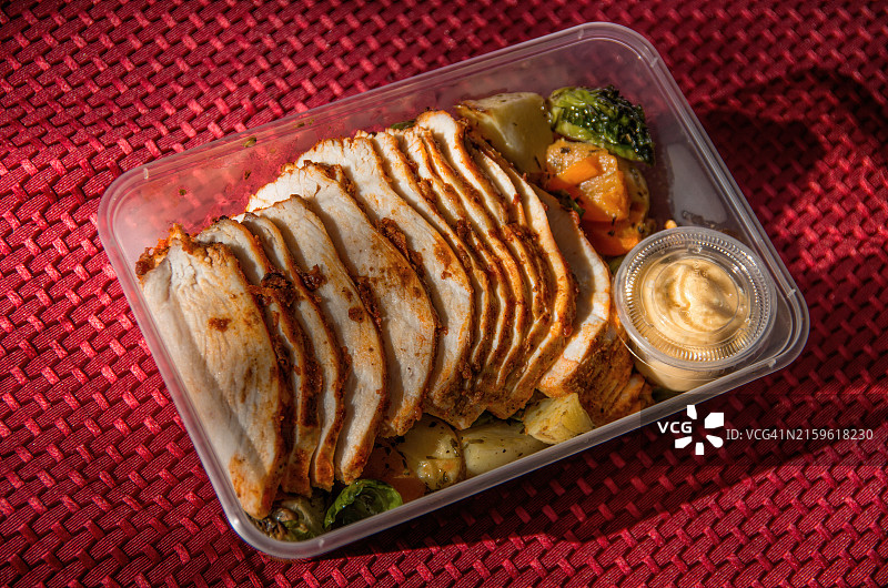 塑料容器装有坦都里鸡胸肉片和烤蔬菜图片素材