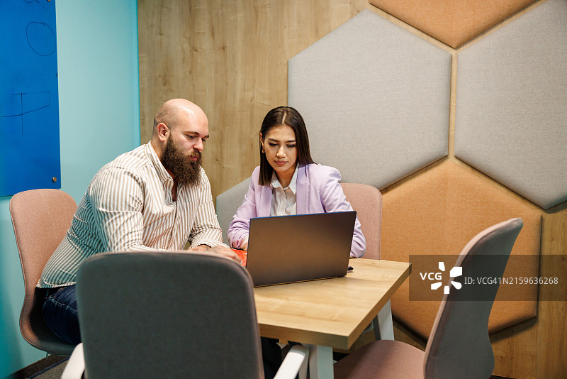 年轻同事在办公舱内共同工作图片素材