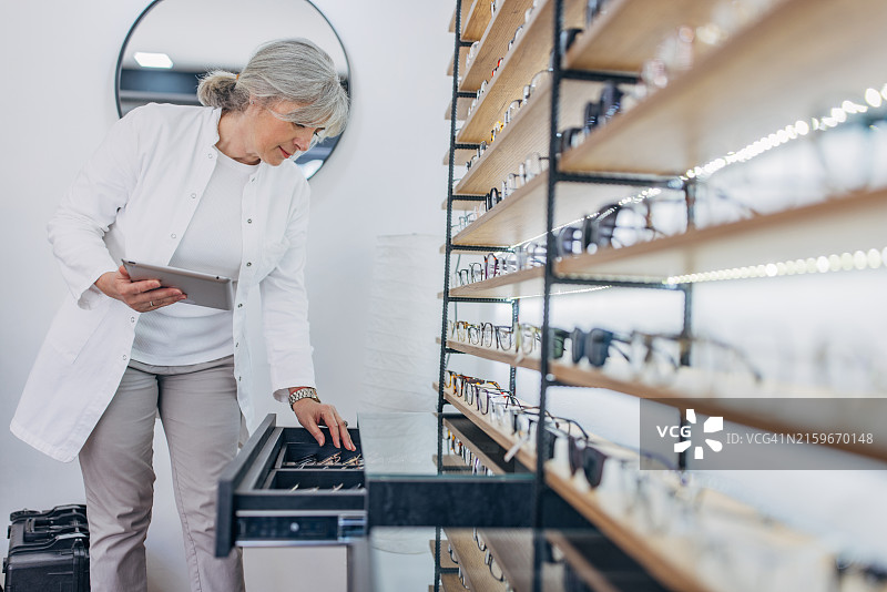 专业人士使用平板电脑检查眼镜抽屉图片素材