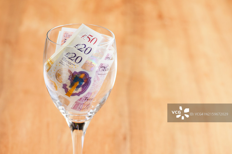 装有纸币的葡萄酒杯图片素材