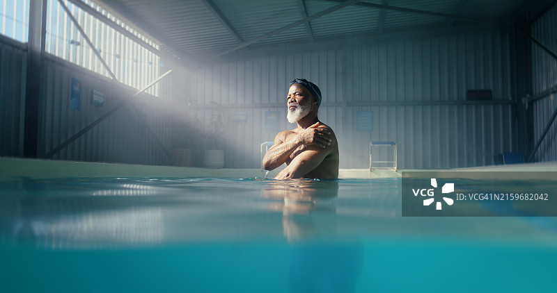 年长的黑人男子在游泳池中进行有氧运动，锻炼身体或训练肌肉。在室内水上中心放松身心的非洲成熟男性，寻求平静或灵感图片素材